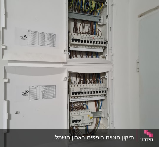 לוח חשמל פתוח עם חוטים ומפסקים